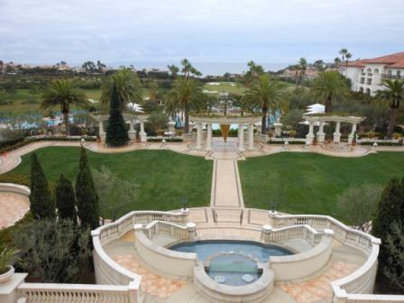 a large lawn with a fountain and a pool
