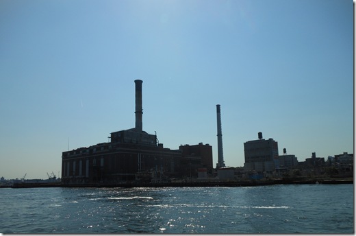 a factory on a small island with Battersea Power Station in the background