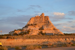 a large rock formation with a trailer parked in front of it with Bell Rock in the background