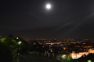 a moon over a city at night