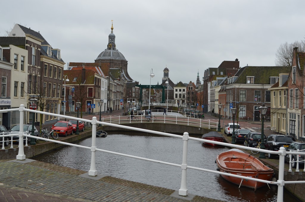 a bridge over a canal with boats and buildings