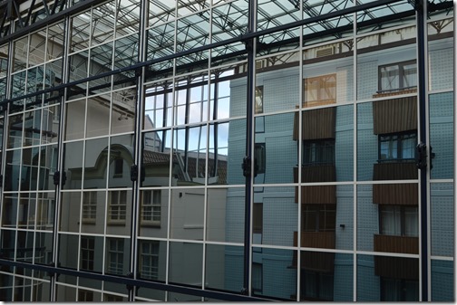 a glass wall with a building reflection