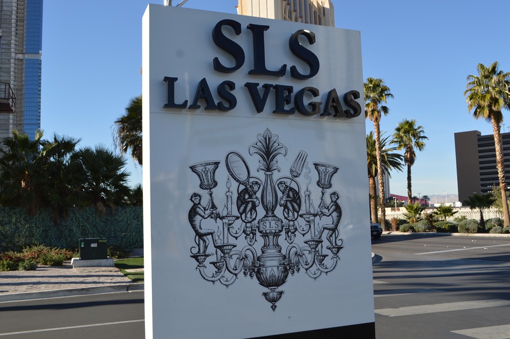 a sign with a picture of a chandelier and a couple of palm trees