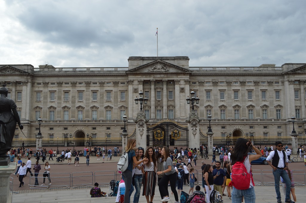 a group of people in front of a large building with Buckingham Palace in the background