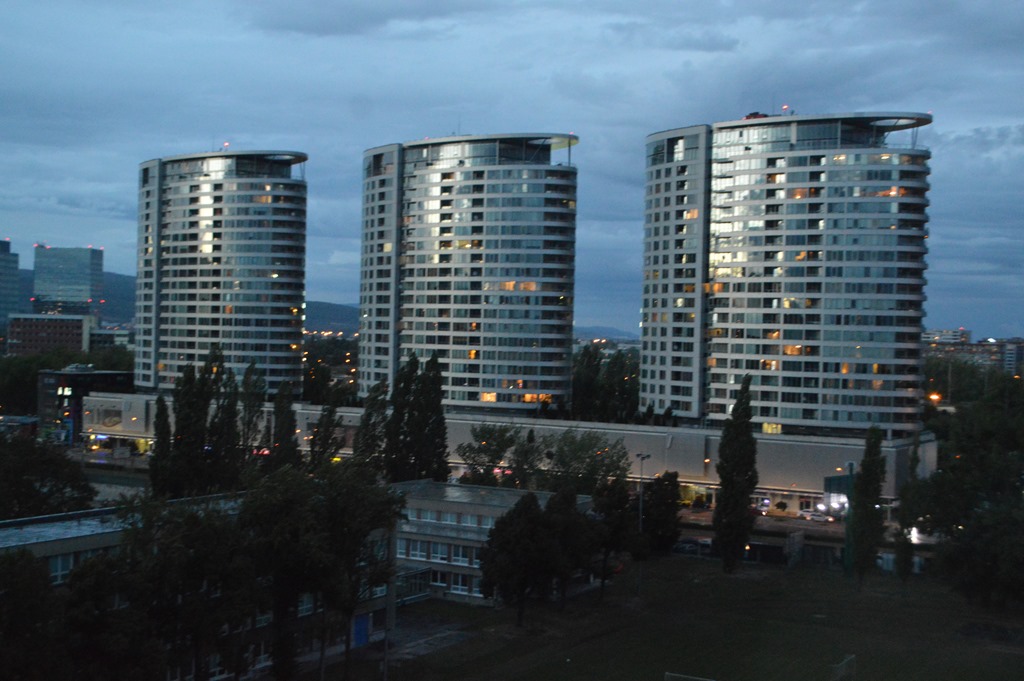 a group of tall buildings with trees and buildings in the background