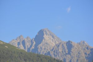 a mountain with trees and blue sky