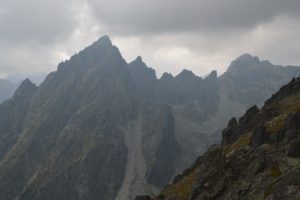 a rocky mountain range with clouds in the sky