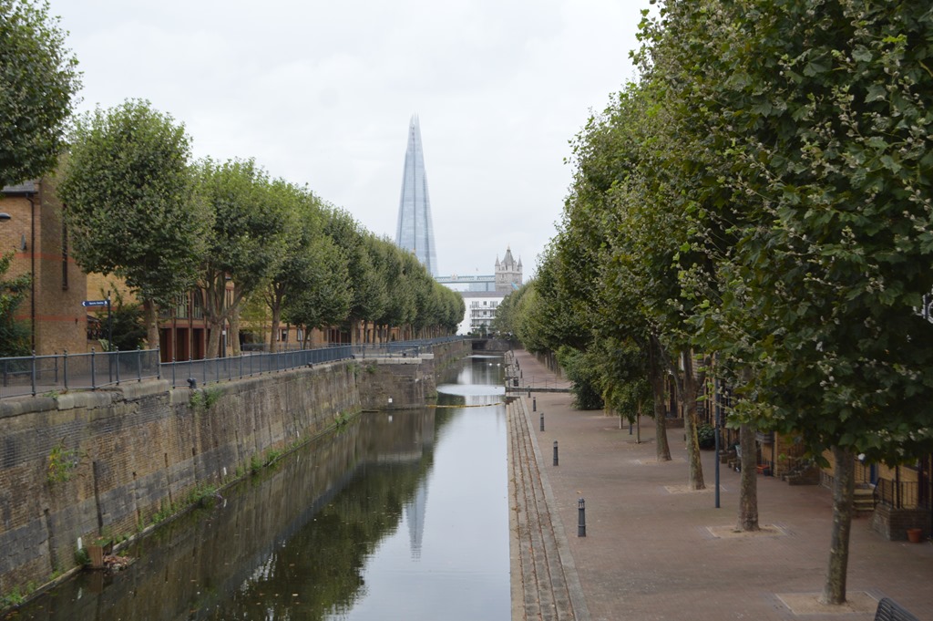a water canal with trees and a building in the background