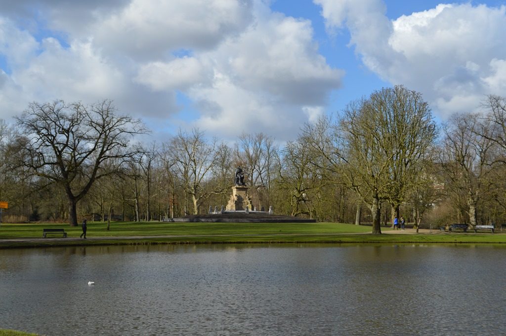 a pond with a statue in the middle of it