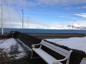 a white bench next to a road