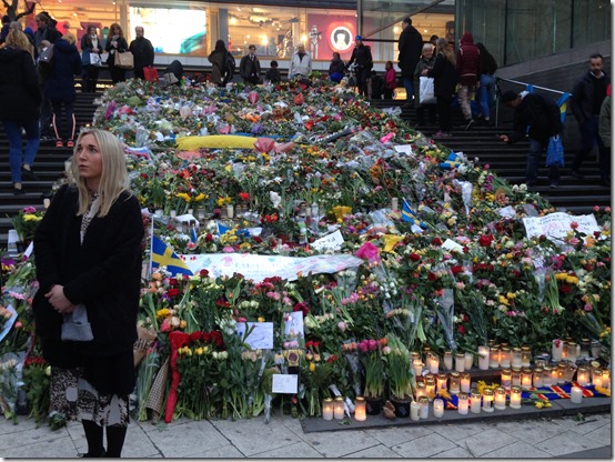 a woman standing next to a pile of flowers