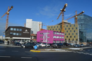 Pink WOW Air Building in downtown Reykjavik surrounded by construction cranes.