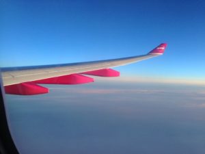 wing of an airplane flying over the clouds