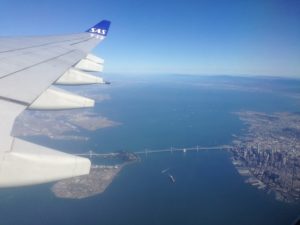 an airplane wing with a bridge and water in the background