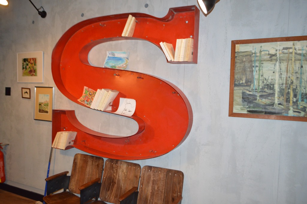 a red letter shaped book shelf with books on it