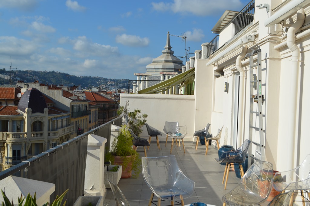 a balcony with chairs and tables