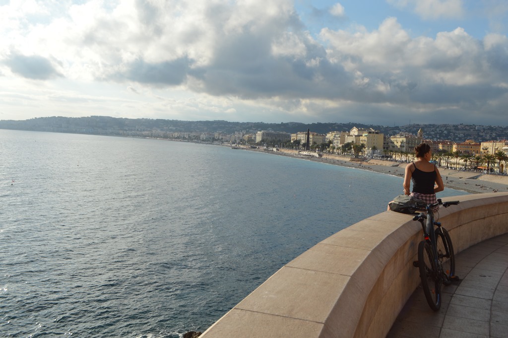 a woman sitting on a ledge overlooking a body of water