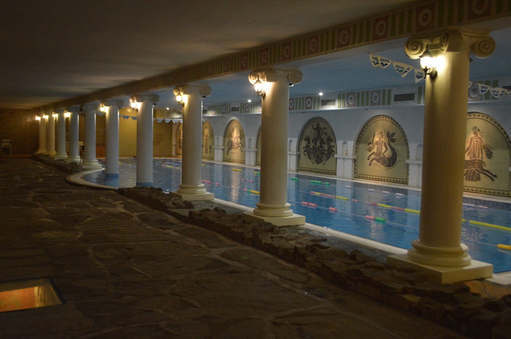 a swimming pool with columns and lights