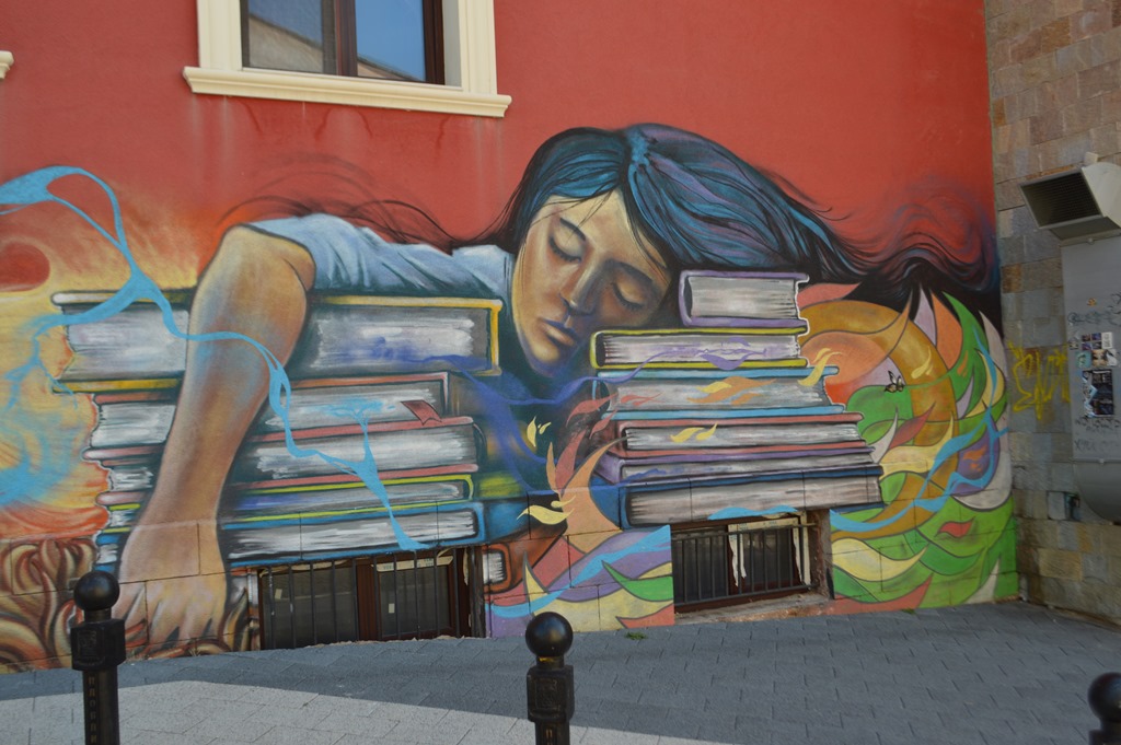a mural of a woman sleeping on a stack of books