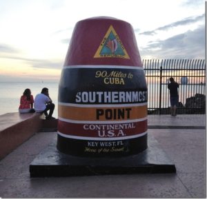 a large cone shaped monument with a sign on it with Southernmost point buoy in the background