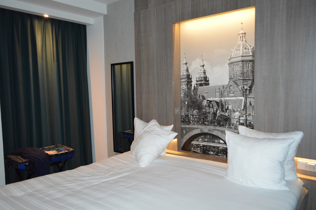 a bed with white pillows and a picture on the wall