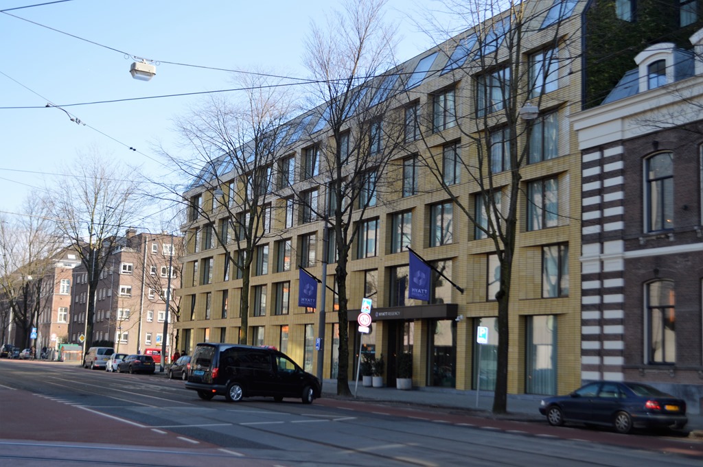 a building with many windows and cars on the street