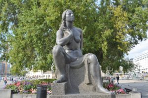 a statue of a woman sitting on a chair