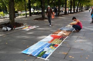 a group of people painting on the sidewalk