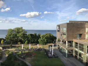 a building with a lawn and trees by the water