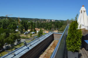 a rooftop of a building with trees and buildings in the background