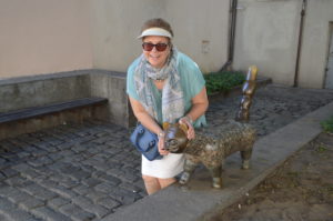 a woman posing with a statue of a cat