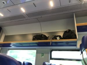 luggage on a shelf on a train