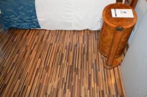 a wooden floor with a bed and a nightstand