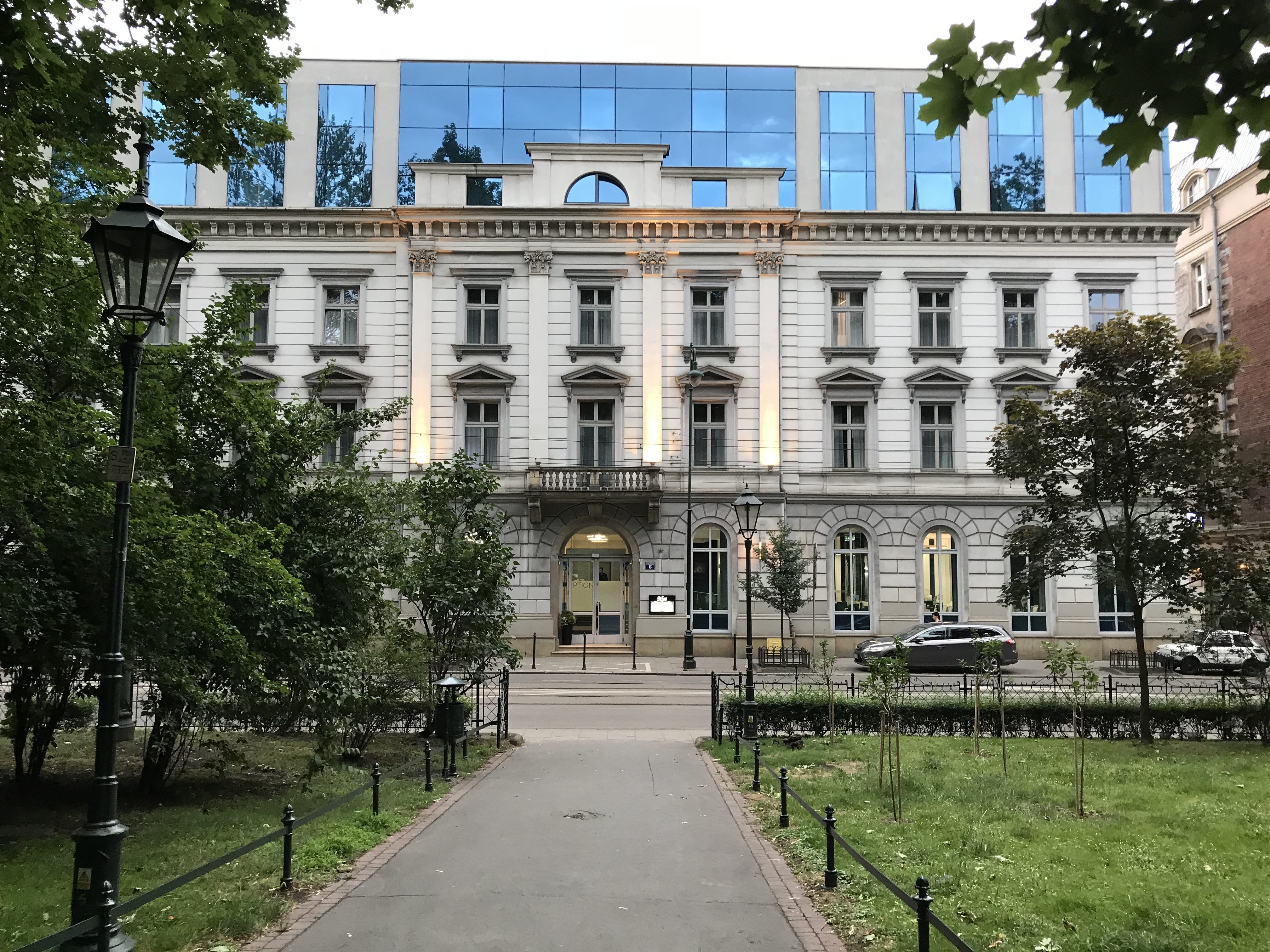 a white building with trees and a walkway