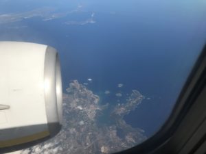 an airplane window with a view of land and water