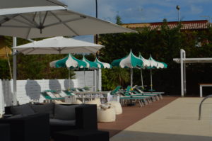 a patio area with chairs and umbrellas