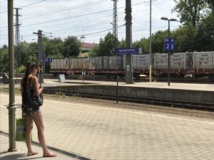 a woman standing on a platform next to a train