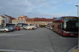 a bus parking lot with many cars and buildings