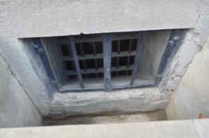 a window with bars in a concrete wall