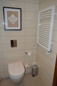 a bathroom with a white tile wall
