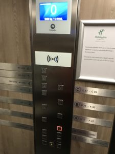 a elevator panel with buttons and signs