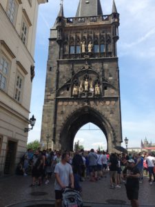 a group of people standing in front of a tall stone tower