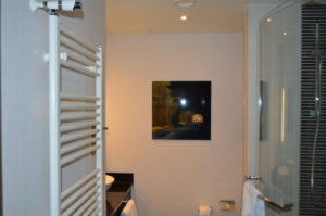 a bathroom with a painting on the wall