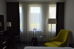 a room with a yellow chair and a suitcase