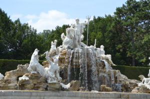 a fountain with statues of animals and a man holding a trident