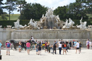 a group of people standing around a fountain