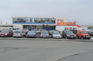 a parking lot with cars parked in front of a building