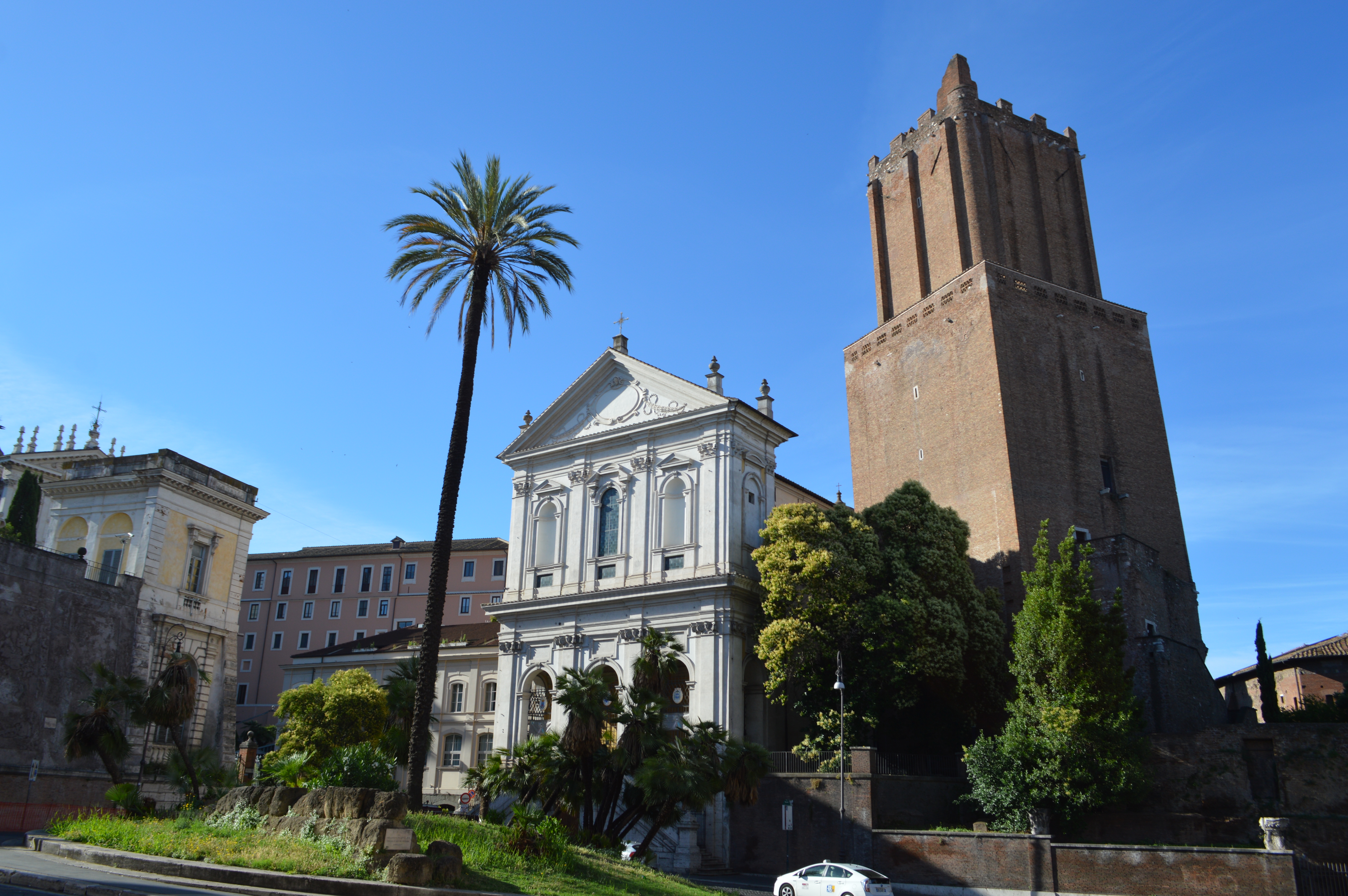 a building with a tall tower and palm tree