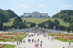 a group of people walking in a park with Schönbrunn Palace in the background