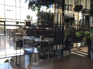 a glass wall with a table and plants in it